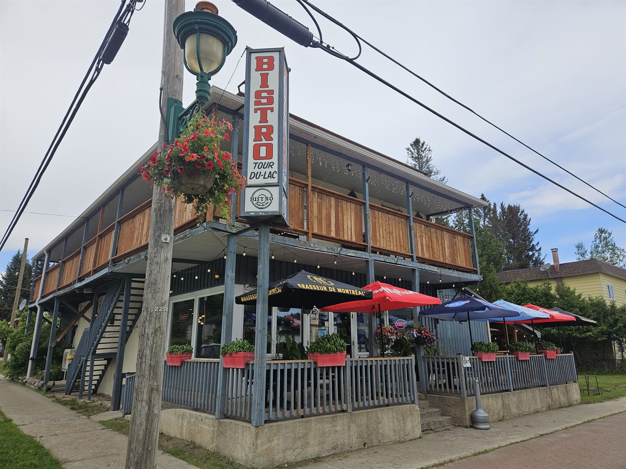 Bistro tour du lac from the street: wooden façade, patio and big red sign